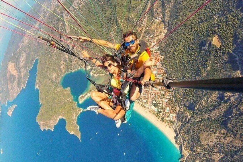 A person paragliding over a coastal area with visible land and water. 3
