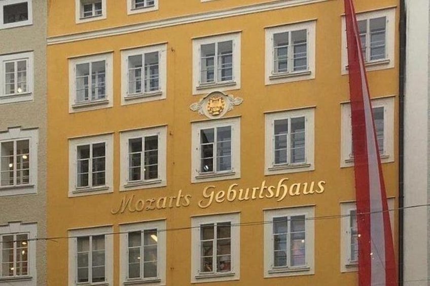 Un bâtiment portant l’inscription « Mozarts Geburtshaus » et sur lequel flotte un drapeau rouge. 2