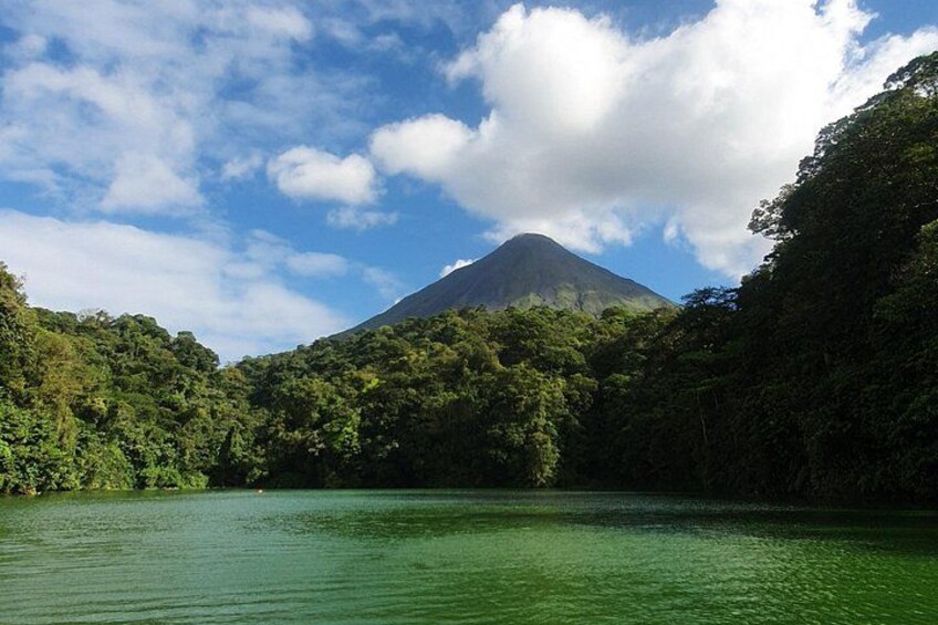 A lake surrounded by dense forest and a mountain in the background. 5