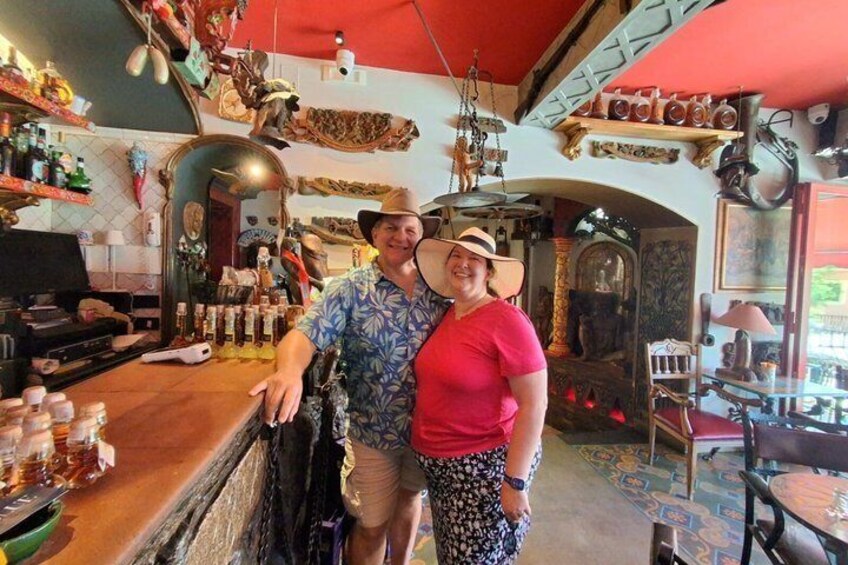 Un bar con interior rústico, estantes de madera y varias botellas. 2