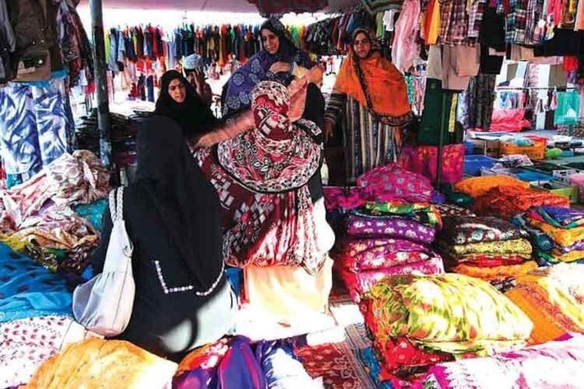 A market with colorful fabrics and textiles on display. 4
