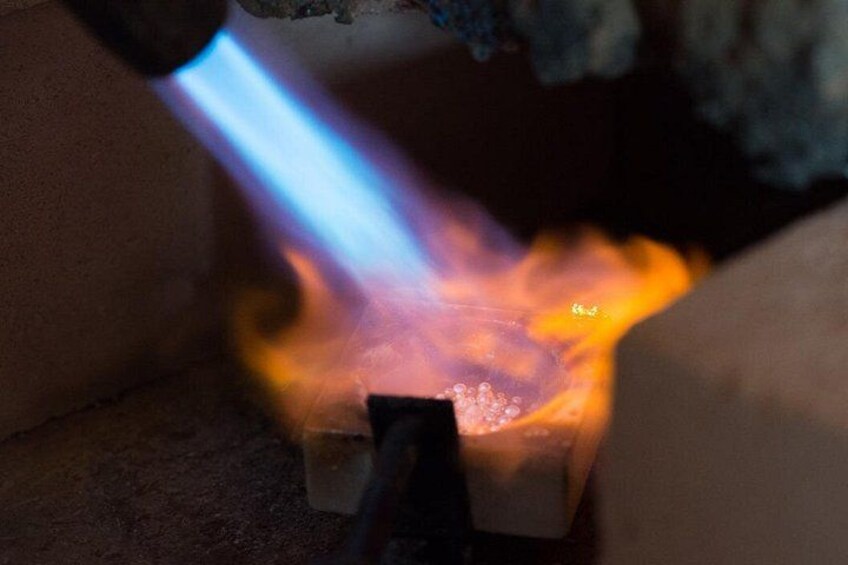 Eine Flamme in Blauheit erhitzt ein Metallobjekt. 1