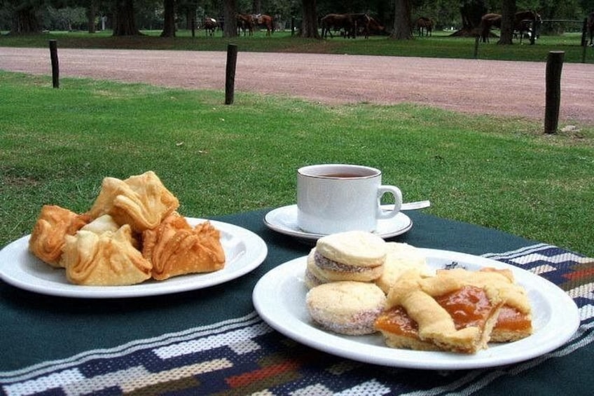 A picnic setup with pastries and a cup of coffee on a blanket. 2