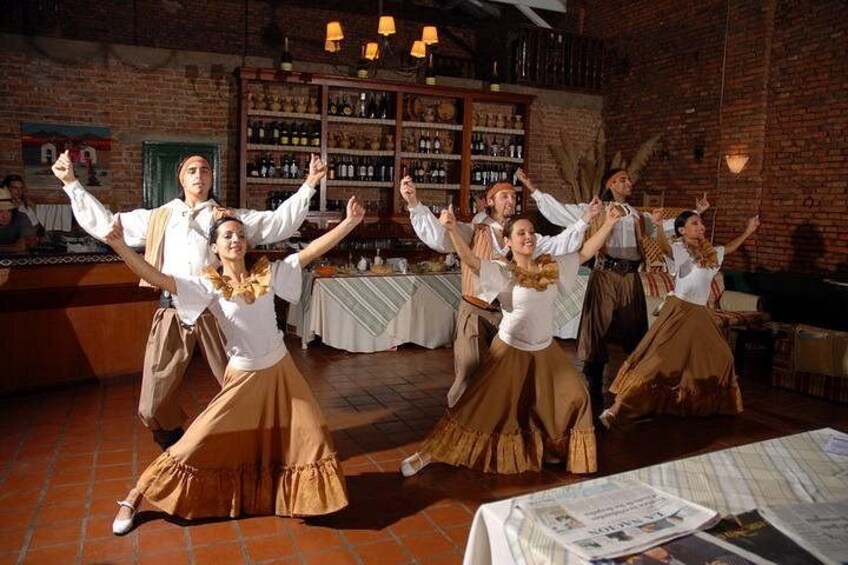 A group of people dancing in a rustic setting with brick walls and wooden furniture. 3