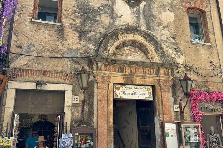 Un bâtiment sur lequel on peut lire l’inscription « Museo della pasta », et une boutique sur laquelle on peut lire l’inscription « DiDomenico ». 2