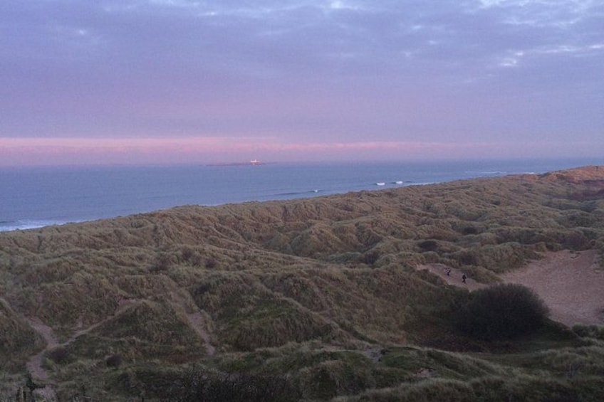 Un paysage côtier avec des dunes et un sentier menant à la plage. 5