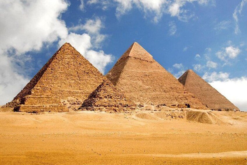 Trois grandes pyramides se dressent dans un paysage désertique. 1