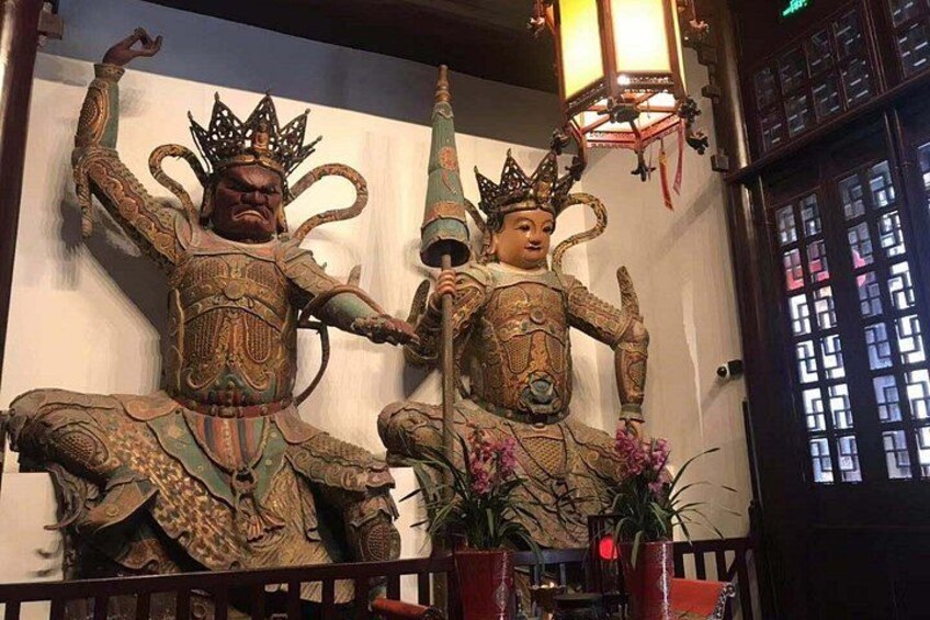 Zwei aufwendig verzierte Statuen mit Kronen, eine davon hält einen Stab, in einem Tempel mit traditioneller chinesischer Architektur. 3