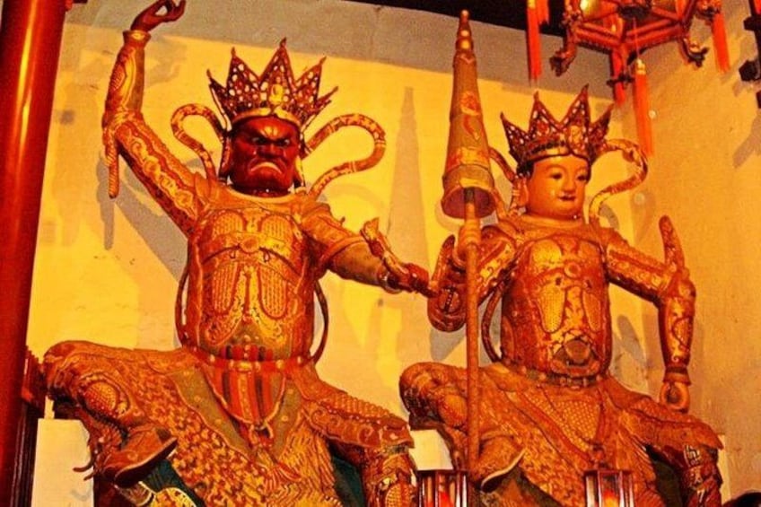 Dos estatuas ricamente adornadas con coronas y múltiples brazos, probablemente representando deidades, en un entorno de templo. 3