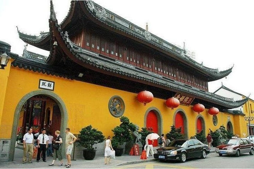 Un edificio tradicional con fachada amarilla, faroles rojos y un cartel con caracteres chinos. 4
