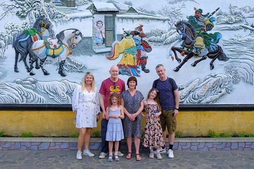 A mural with horses and riders, a building, and a group of people standing in front. 5