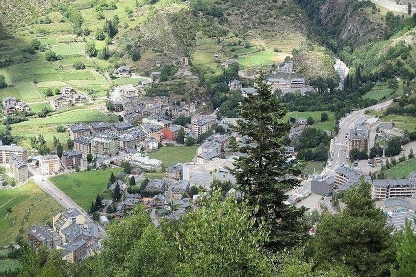 A town nestled in a valley with buildings, roads, and greenery. 3