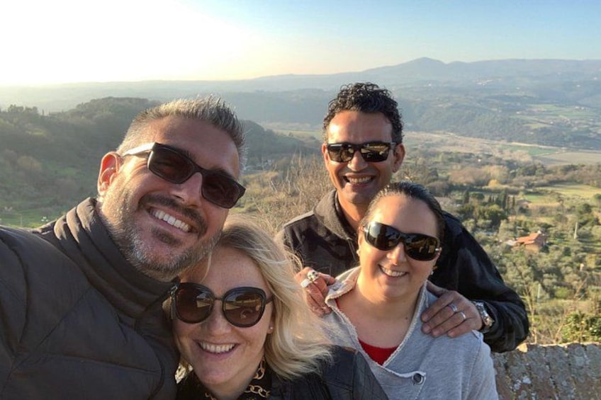 A group of people taking a selfie with a scenic landscape in the background. 4