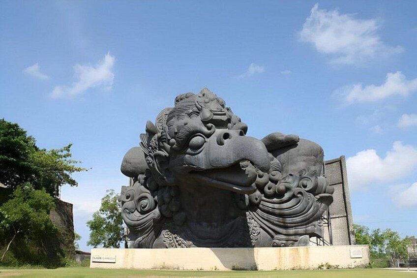 Una gran escultura de piedra de una criatura mítica, con detalles intrincados y un pedestal con una placa. 4