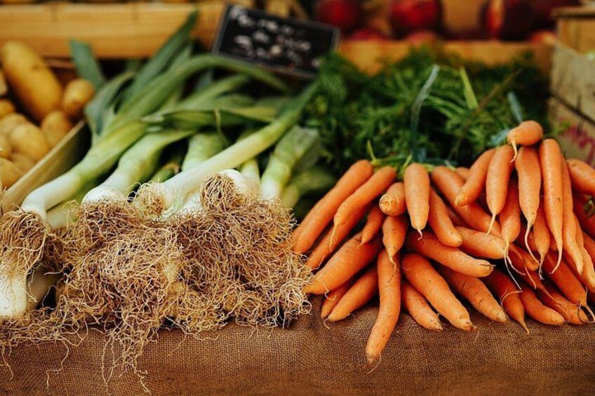 A variety of fresh vegetables including carrots, green onions, and ginger. 4