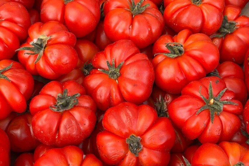 A close-up of red tomatoes with green stems. 3