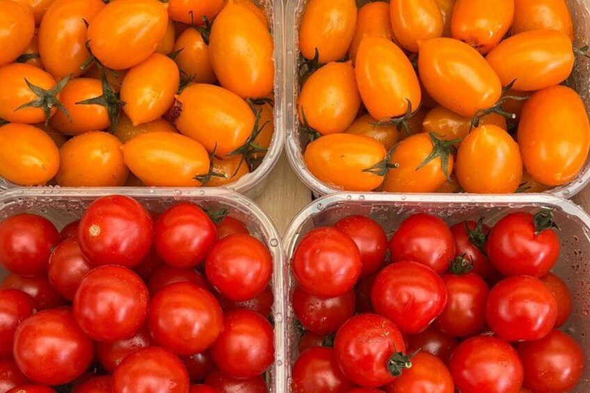 Four plastic containers filled with cherry tomatoes, two with yellow and two with red tomatoes. 3
