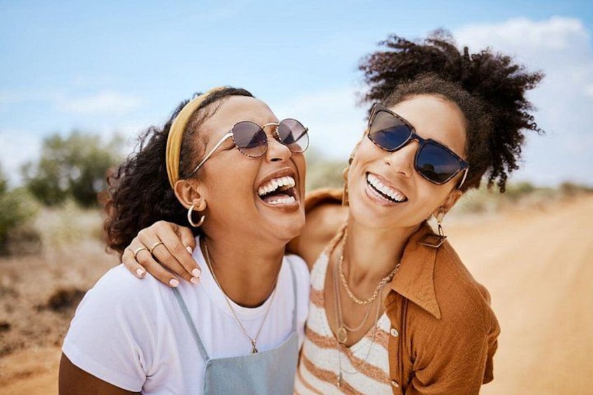 Two people embracing in a desert landscape with sparse vegetation. 2