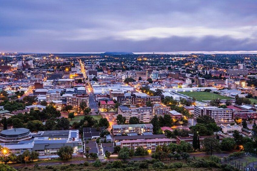 A cityscape at dusk with illuminated buildings and streets. 3