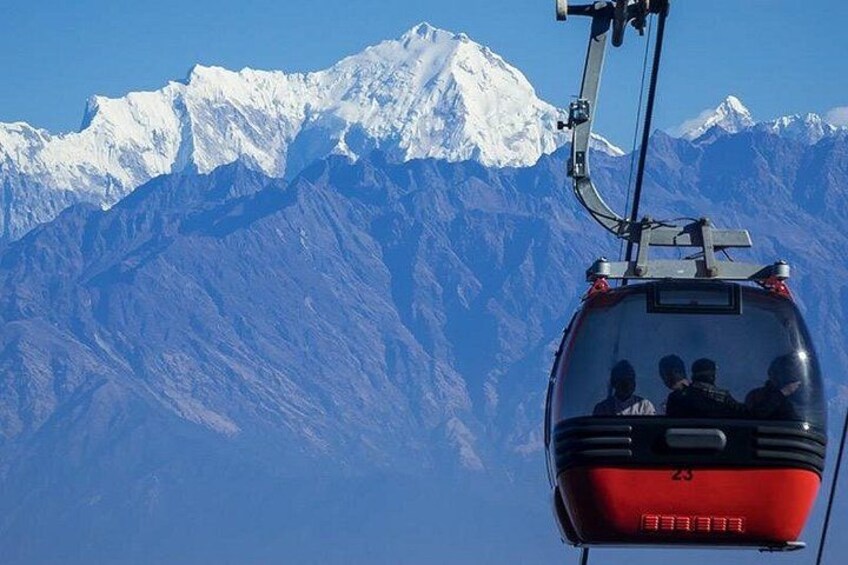 Une télécabine transportant des passagers, avec en arrière-plan des montagnes enneigées. 1