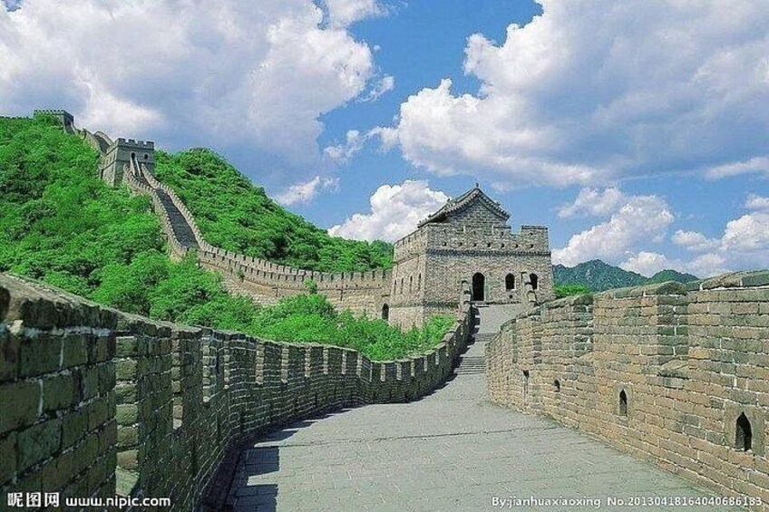 The Great Wall of China with lush green vegetation and a clear sky. 4