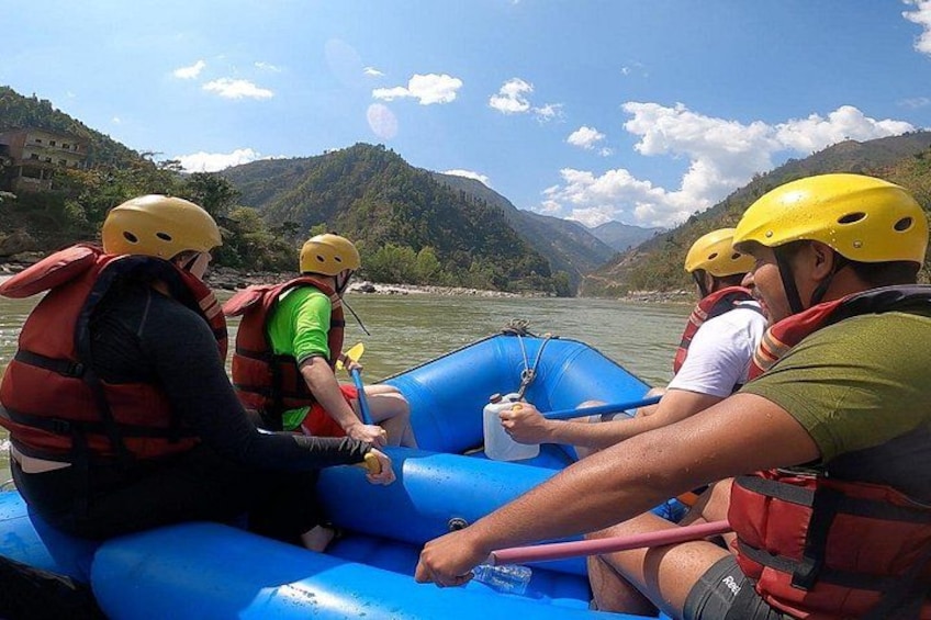 Des personnes pratiquent le rafting sur une rivière, portant des casques et des gilets de sauvetage, et sont entourées de montagnes. 4