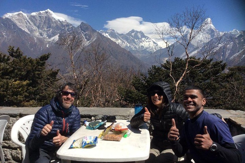 Three people sitting at a table with a mountain backdrop. 1