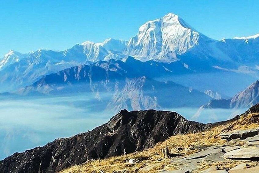 A mountain range with a prominent peak, rocky terrain, and a clear sky. 4