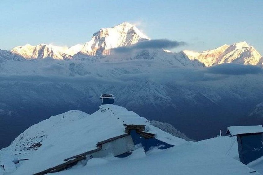 A snow-covered mountain peak with a small structure on the slope. 1