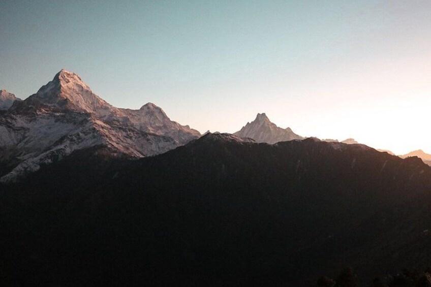 A mountain range with snow-capped peaks during sunset. 3