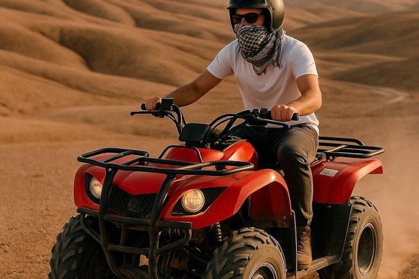 A person riding a red ATV in a desert with sand dunes. 1