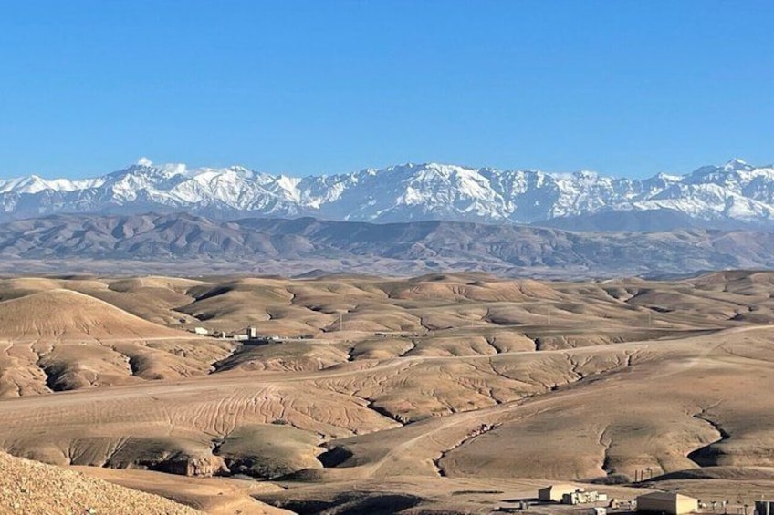 A vast desert landscape with rolling hills and a mountain range in the background. 2