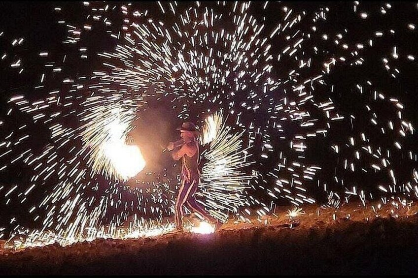 A person performing a firework display with sparks flying around. 2