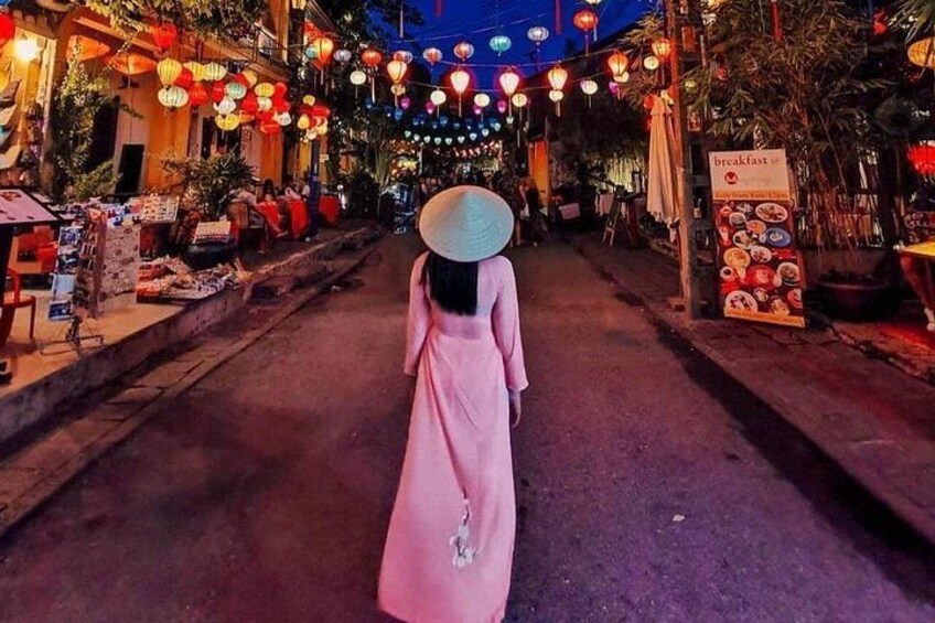 A street lined with shops and food stalls, decorated with hanging lanterns. 1