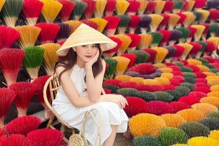 A person sitting amidst a field of colorful fans. 3