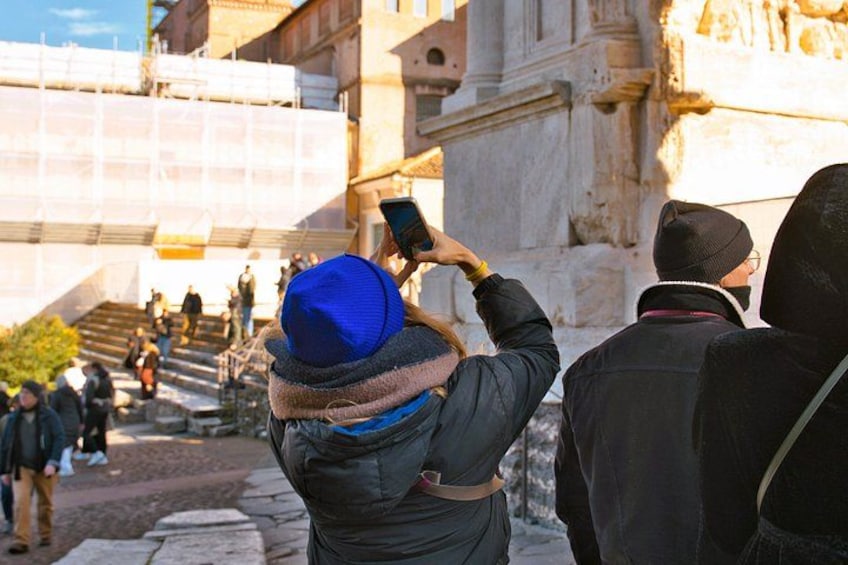 Eine Person fotografiert mit einem Smartphone, eine steinerne Treppe und ein Gebäude im Hintergrund. 5