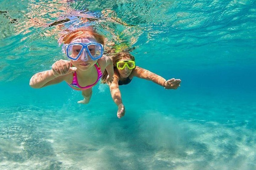 Deux personnes font de la plongée avec tuba dans une eau cristalline et bleue. 5