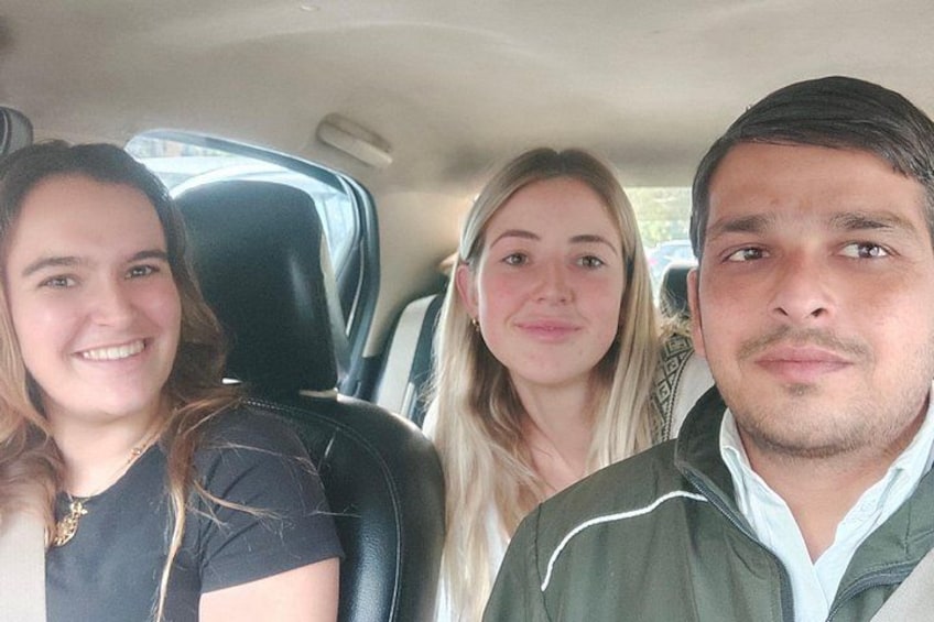 Three people seated in a car with a visible seatbelt. 3