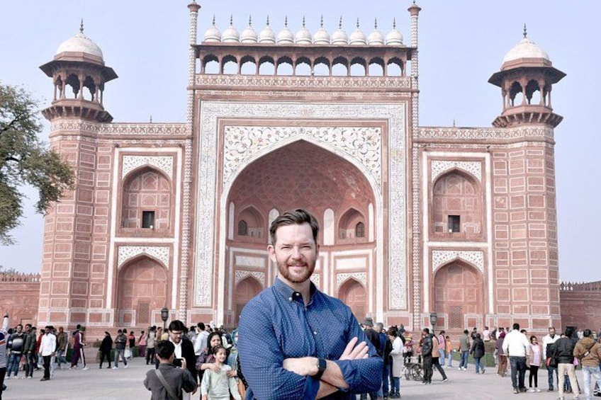 A large historical building with intricate architecture, a crowd of people, and a clear sky. 4