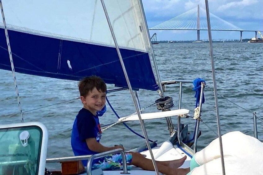 En person på sejlbåd med en bro i baggrunden. 2