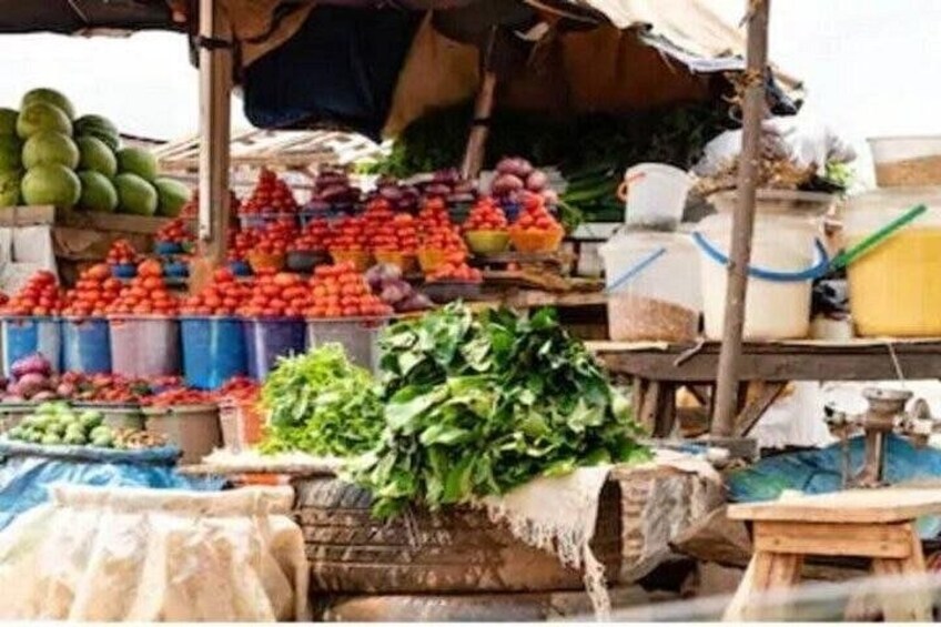A market stall with various fruits and vegetables, including tomatoes, watermelons, and leafy greens. 3