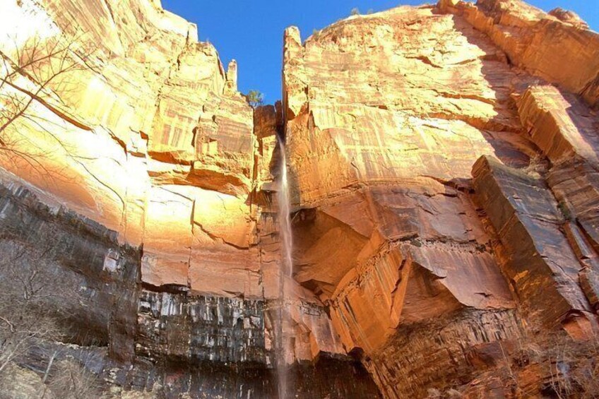 Un canyon aux formations rocheuses stratifiées et une cascade. 5