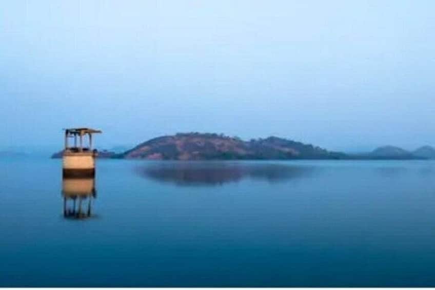 A calm body of water with a small boat and a distant island. 5