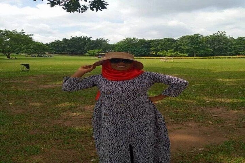 A person standing in a grassy field with trees in the background. 4