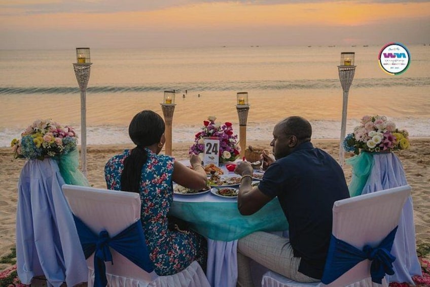 A beachside dining setup with a table, chairs, and a view of the ocean. 5