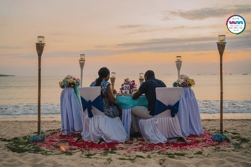 A beachside dining setup with tables, chairs, and decorative elements. 4