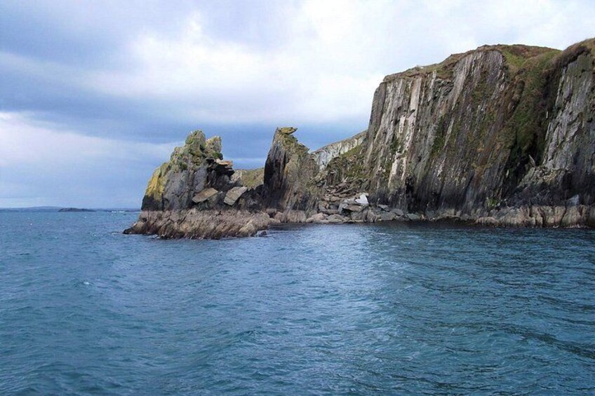 A rocky coastline with cliffs and calm sea. 4
