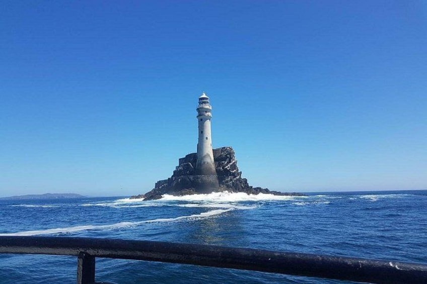 A lighthouse on a rocky outcrop surrounded by the ocean. 3