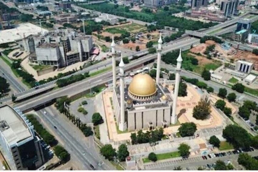 Eine Vogelperspektive zeigt eine Moschee mit einer großen, goldfarbenen Kuppel, Minaretten und einem umlaufenden Innenhof. 4