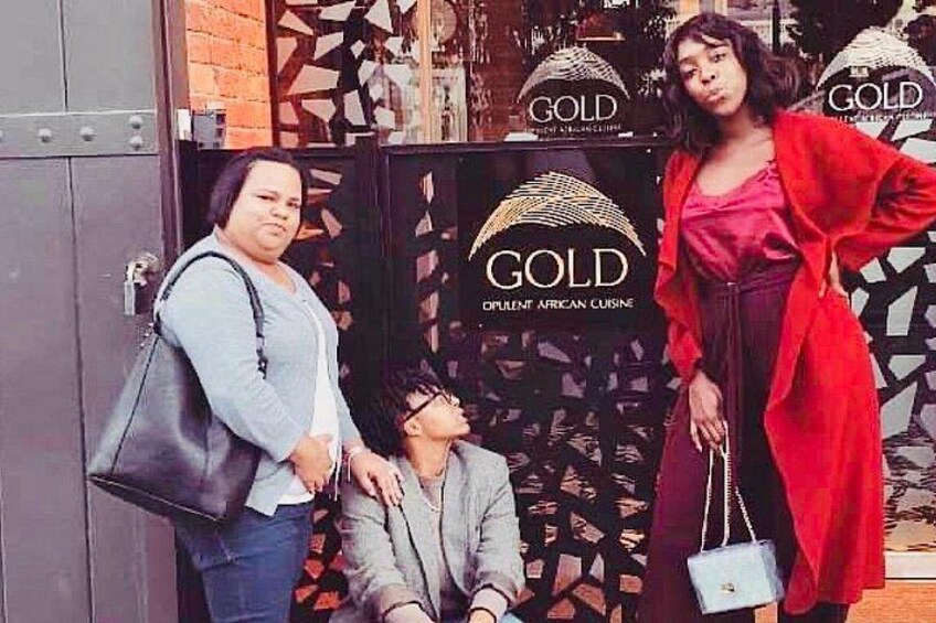 A storefront with a sign reading 'GOLD' and 'OPULENT AFRICAN CUISINE'. 2